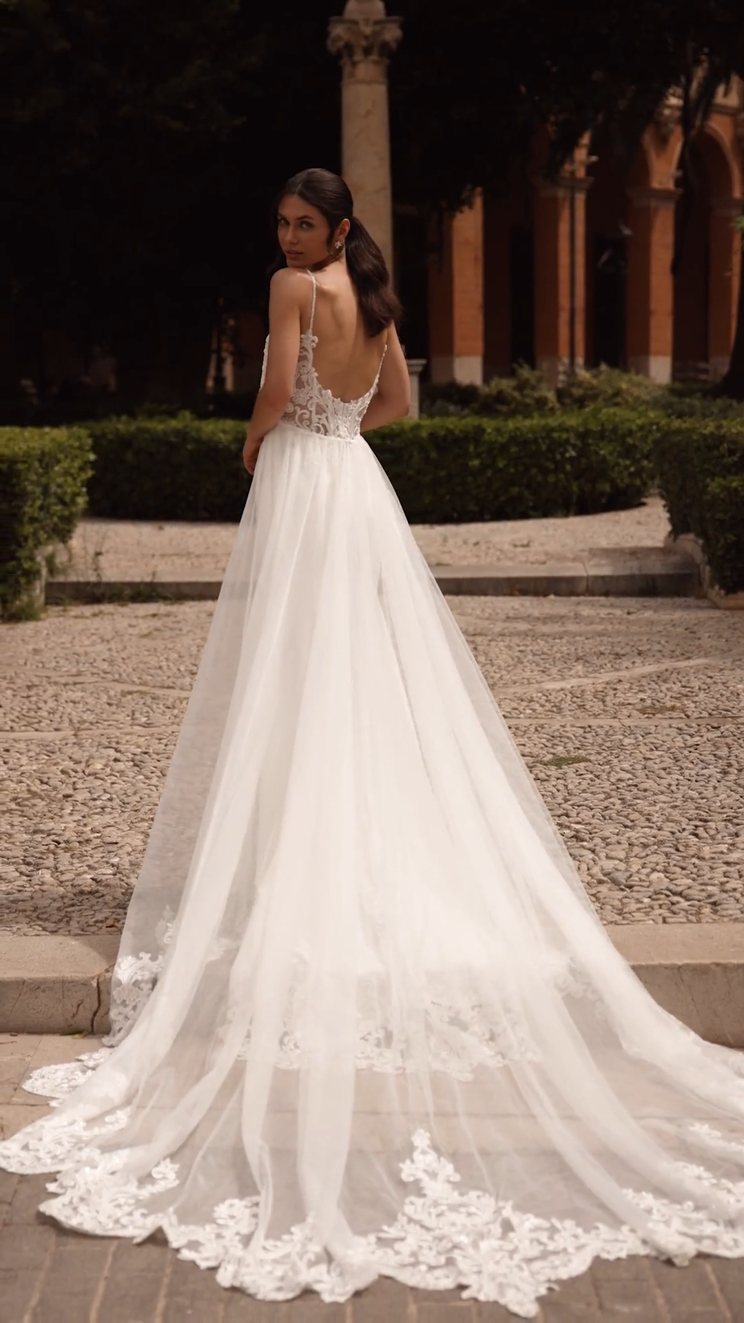 Bride wearing an ivory crepe convertible wedding dress with detachable tulle overskirt