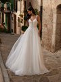Bride wearing lightweight tulle wedding dress with deep sweetheart neckline and spaghetti straps