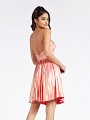 Thigh length coral party dress with flowy pleated skirt and open back with straps