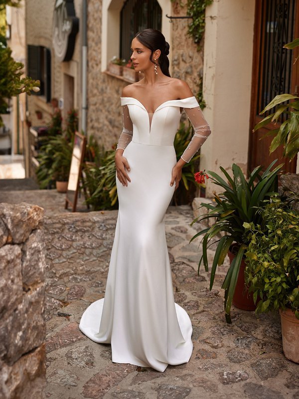 Bride Wearing Clean Crepe Wedding Dress With Off The Shoulder Neckline And Pearl Sleeves