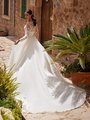 Back view of bride walking in ivory wedding dress with chapel train and illusion long sleeves