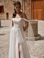 Bride wearing a lace and pleated tulle wedding dress with leg slit