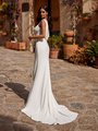 Back view of bride in ivory crepe wedding dress with low v-shaped back with chiffon detailing